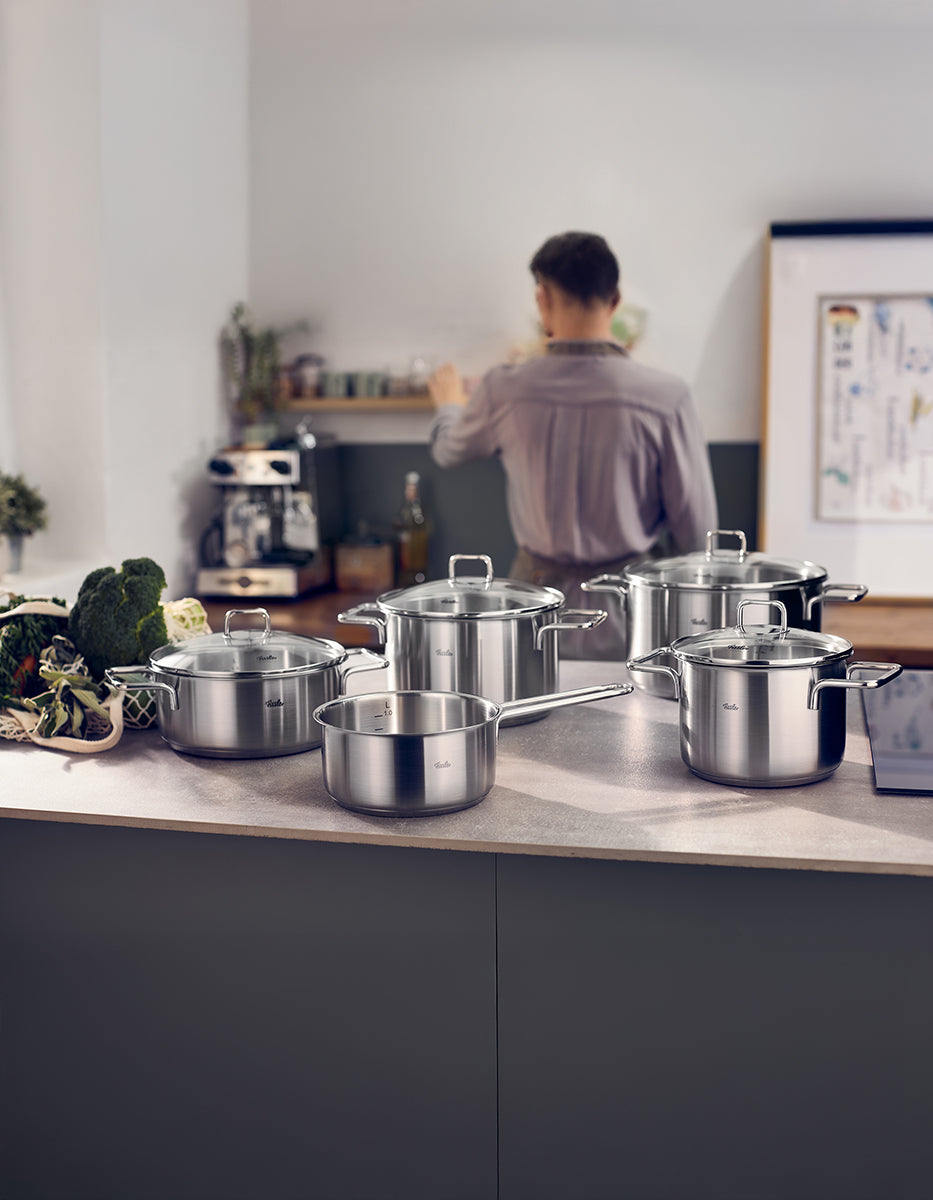 Das Fissler SatiTherm Topfset 5-tlg. mit Glasdeckel glänzt auf einer modernen Küchentheke und ist ein Beispiel für deutsches Qualitätskochgeschirr.