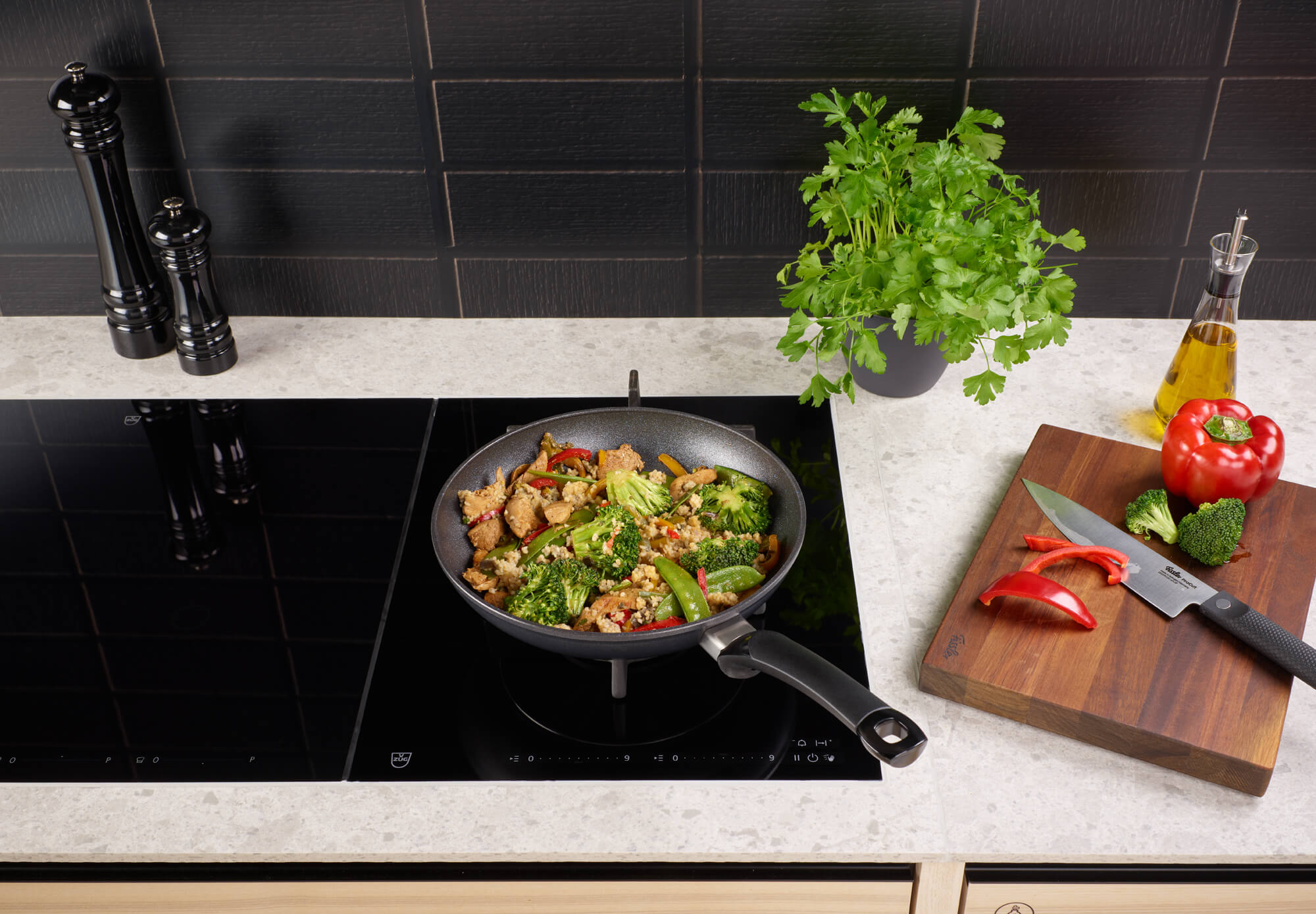Fissler Adamant® Classic pan set in use on the stove with stir-fry, fresh ingredients - precision and durability "Made in Germany".